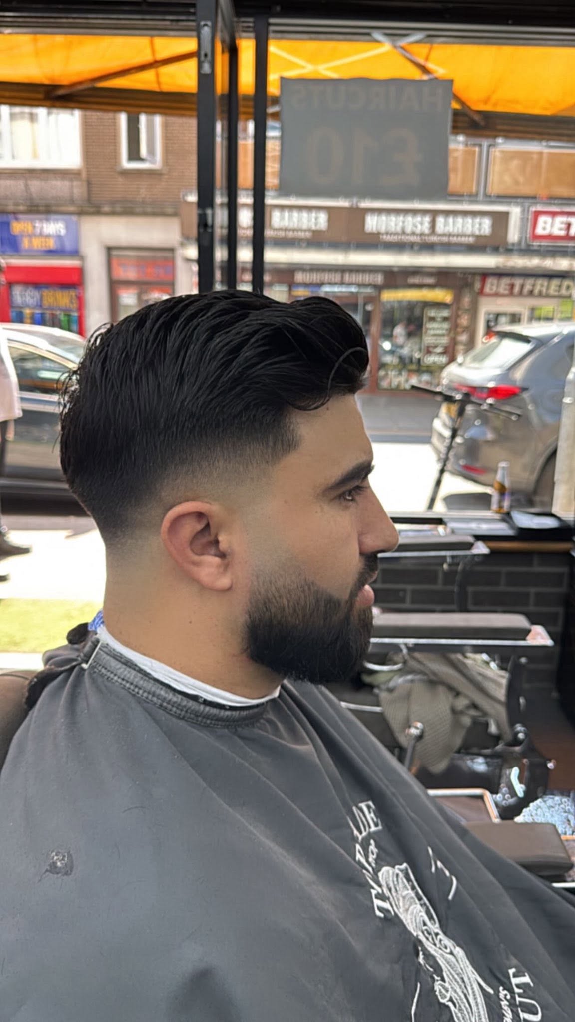 Low drop skin fade with textured side swept flow and full beard trim
